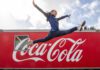 Coca-Cola announced as Soft Drinks Partner of Glasgow Commonwealth Games A woman jumps over the Coca-Cola logo.