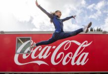 Coca-Cola announced as Soft Drinks Partner of Glasgow Commonwealth Games A woman jumps over the Coca-Cola logo.
