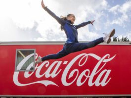 Coca-Cola announced as Soft Drinks Partner of Glasgow Commonwealth Games A woman jumps over the Coca-Cola logo.