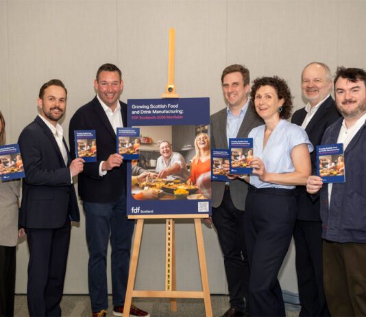 Politicians urged to support food and drink ahead of election A group of politicians stand around an easel with an advert for the Food & Drink Federation Scotland on it.