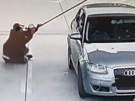 Fuel value losses increase across forecourts A person sits in a forecourt fuel station holding a fuel nozzle up close to their face.