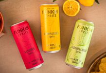 Funkin freshens up RTDs with new Spritz range Cans of Funkin Spritz are laid out across a table with sliced oranges above them and a bowl of crisps to the bottom right and olive to the top left.