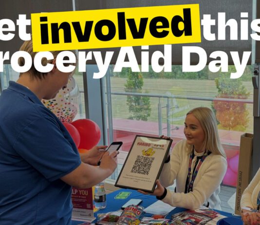 Rallying support for GroceryAid Day 2026 A person attends a Haribo stand to scan a QR code with the slogan 'Get involved this GroceryAid Day'.