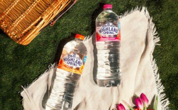 Highland Spring unveils new Flavoured Water range Bottles of Highland Spring Orange & Passionfruit and Summer Berries lie on a picnic scene with a wicker basket in the background.