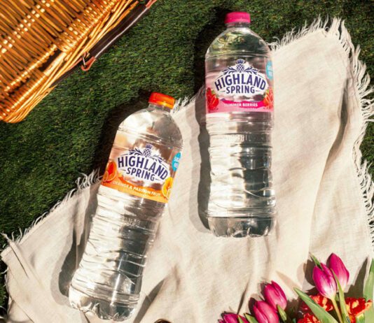 Highland Spring unveils new Flavoured Water range Bottles of Highland Spring Orange & Passionfruit and Summer Berries lie on a picnic scene with a wicker basket in the background.
