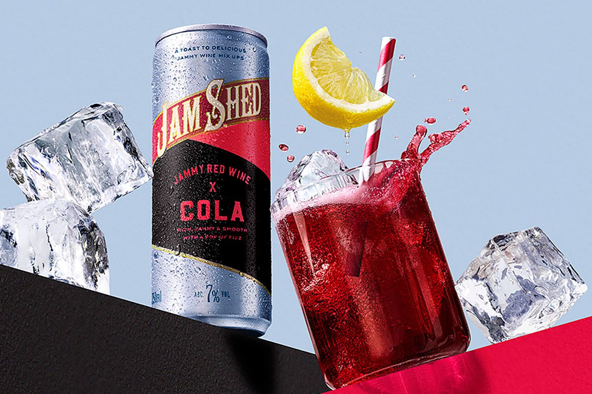 Promotional image for the launch of Jam Shed Jammy Red Wine & Cola cans with a can of the drink next to a glass with the drink inside.