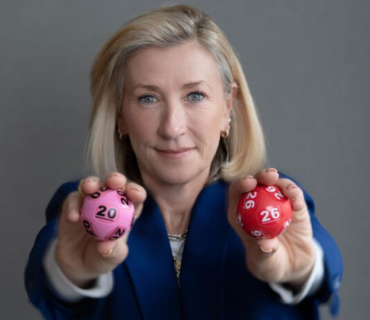 National Lottery set to launch two new games this summer Andria Vidler, chief executive at Allwyn UK, holds two lottery balls with a 20 and a 26 on them.