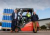 Mackie’s acquires new facility to grow distribution capacity L–R Stuart Common, MD at Mackie's, Roddy Adam, site supervisor, and Mac Mackie, chairperson, are gathered round a forklift truck that is carrying Mackie's ice cream containers.