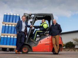 Mackie’s acquires new facility to grow distribution capacity L–R Stuart Common, MD at Mackie's, Roddy Adam, site supervisor, and Mac Mackie, chairperson, are gathered round a forklift truck that is carrying Mackie's ice cream containers.