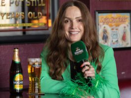 Magners set to ‘Share the Craic’ this summer Emma Doran sits in a pub with pint of Magners cider and a bottle on the table next to her.