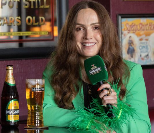 Magners set to ‘Share the Craic’ this summer Emma Doran sits in a pub with pint of Magners cider and a bottle on the table next to her.