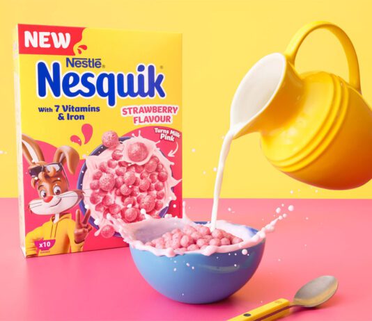 Nesquik introduces new Strawberry flavour A box of Nesquik Strawberry cereal stands behind a bowl with the cereal inside and a yellow jug which pours milk into the bowl.