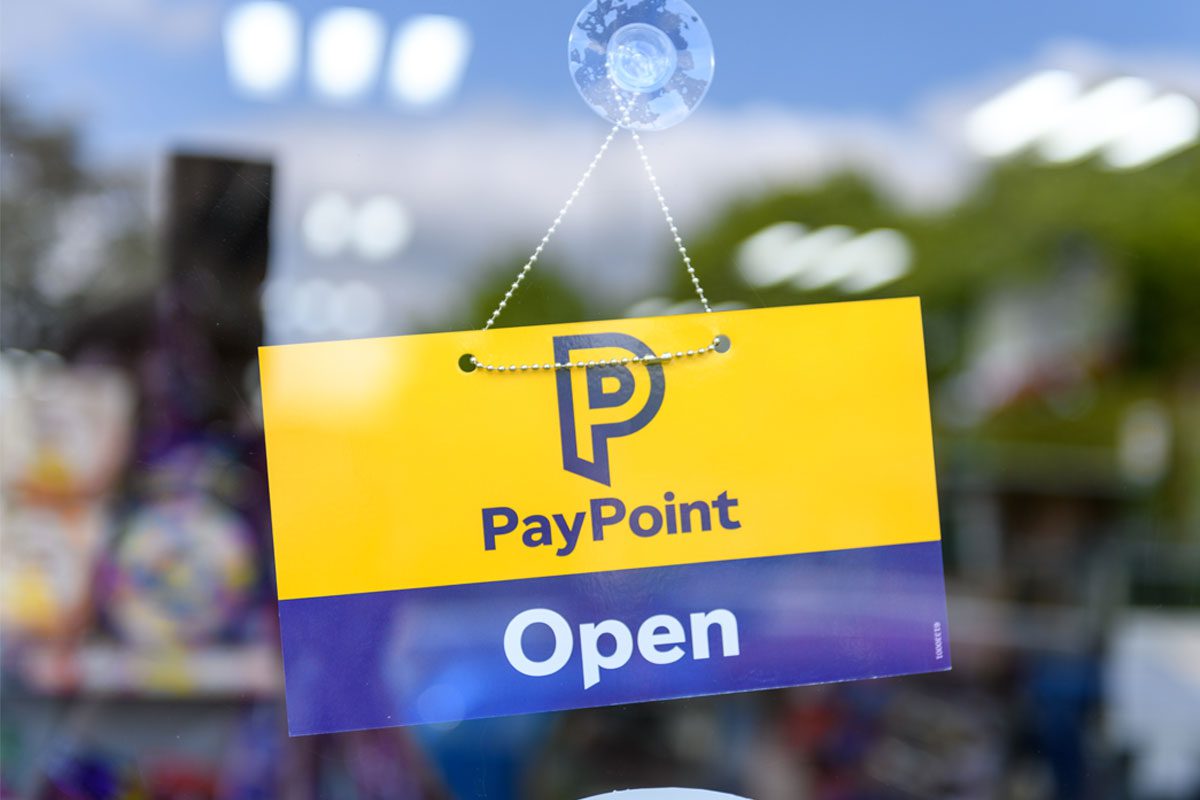 A door has a PayPoint open sign hanging on it.