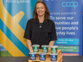 Yester Farm Dairies rolls out in Scotmid stores A woman stands behind a table with pots of Yester Farm Dairies Cottage Cheese on it.