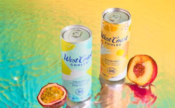 West Coast Coolers land across Scottish shelves Cans of West Coast Cooler Original and West Coast Cooler Sunburst stand on a watery surface with a passionfruit and peach standing next to them.