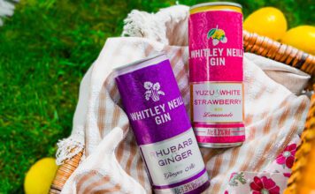 Whitley Neill enters into RTD market Cans of Whitley Neill Rhubarb & Ginger with Ginger Ale and Yuzu & White Strawberry with Lemonade sit in a wicker basket on grass with lemons around the basket.