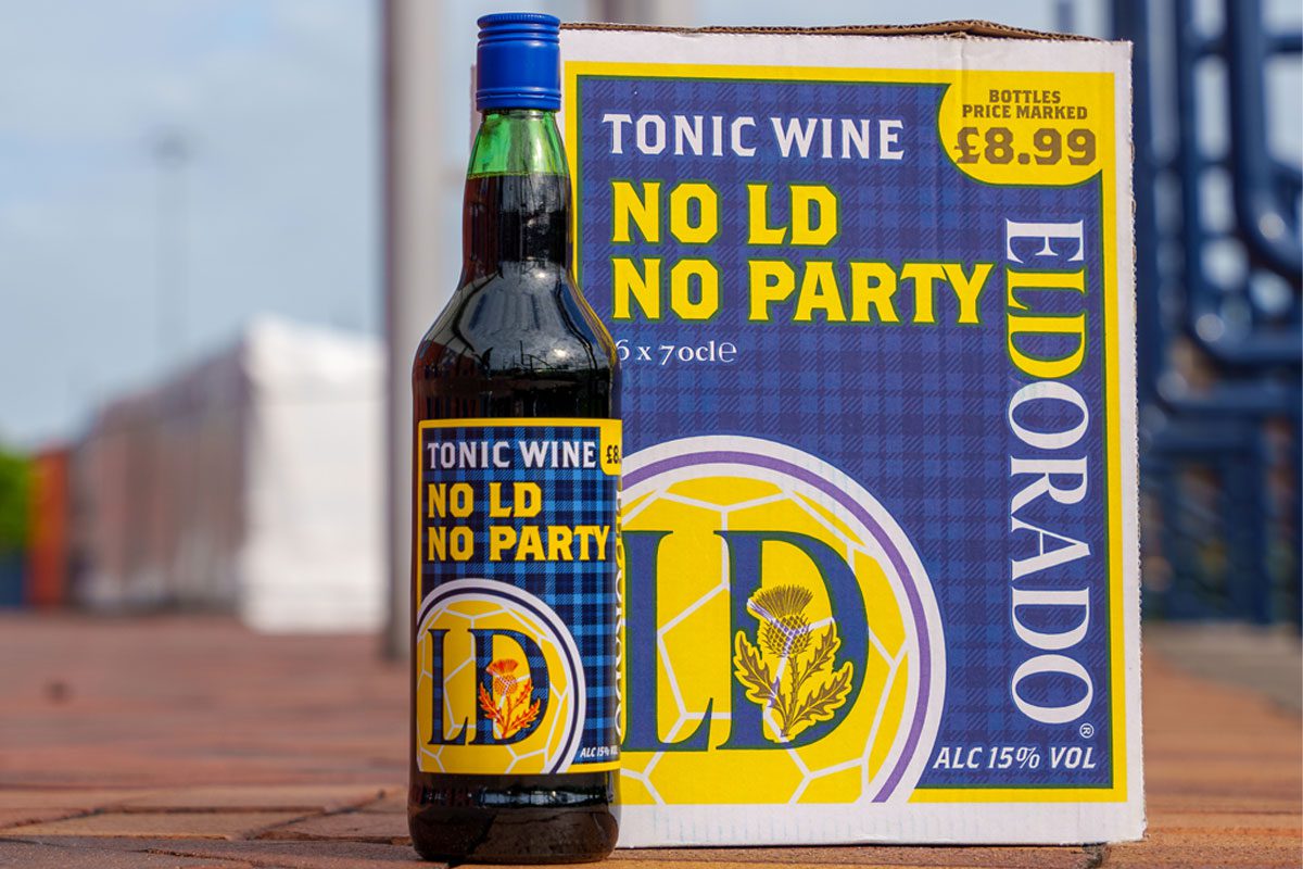A bottle of Eldorado Tonic Wine with the 'No LD, No Party' limited edition design stands next to a crate with the same design on it.
