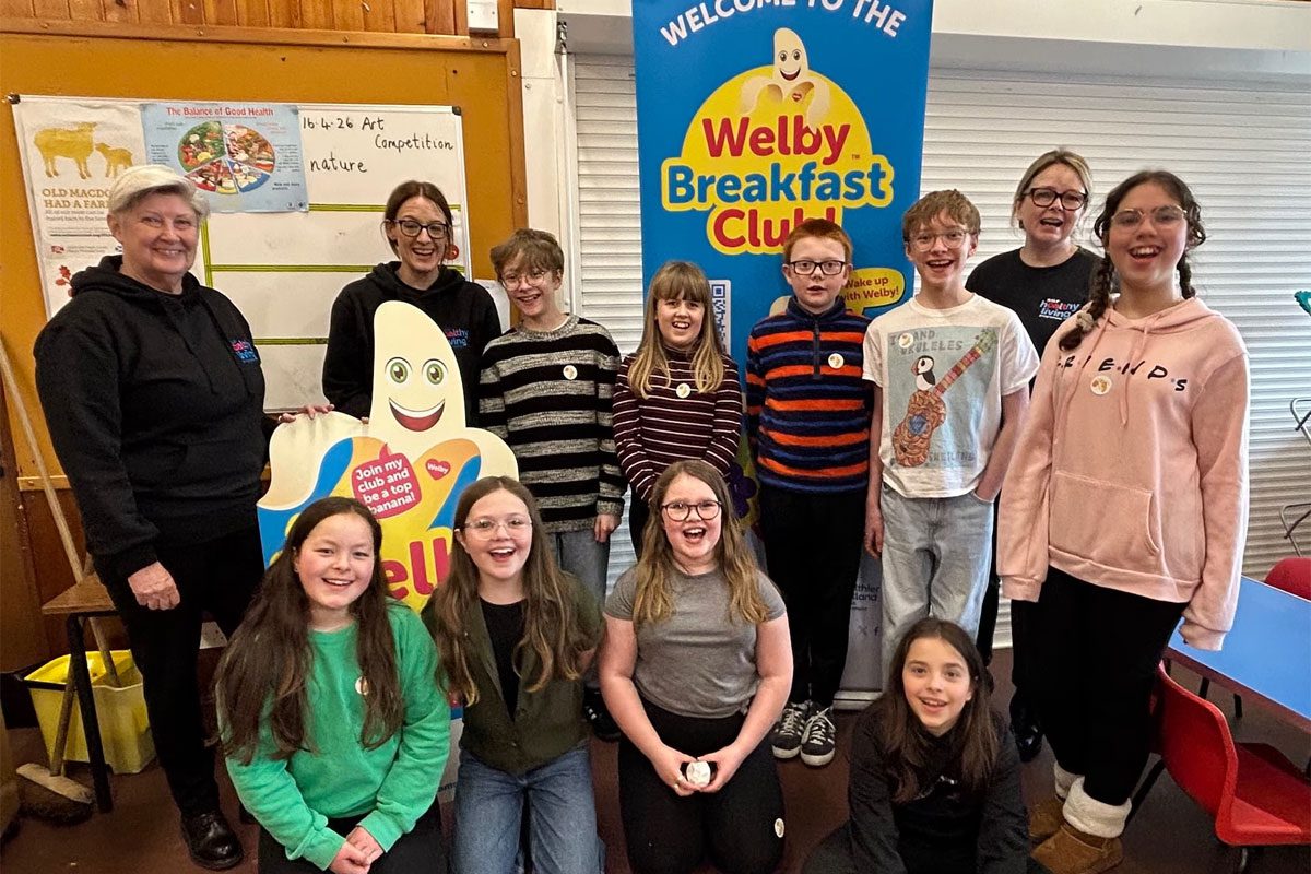 Members of the Healthy Living Programme team stand with school pupils from a local primary school in Shetland.