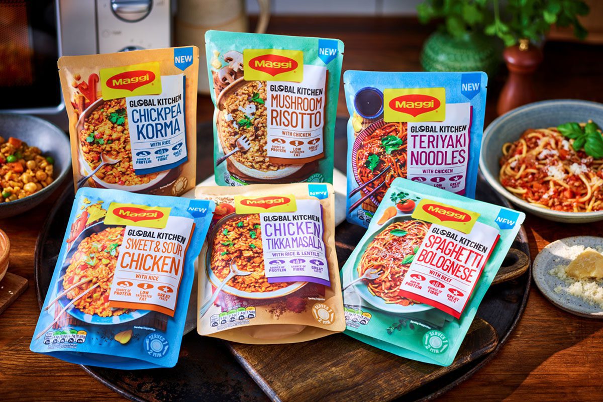 Packs of Maggi Global Kitchen ready meals sit on a counter with the meals served in bowls around them.