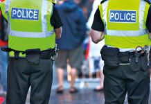 Over 1,300 arrests made in first year of Retail Crime Taskforce Two police officers stand with their backs to the camera in the middle of a busy street.