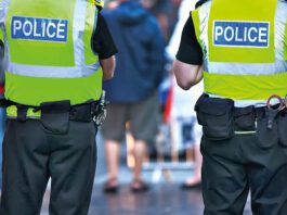 Over 1,300 arrests made in first year of Retail Crime Taskforce Two police officers stand with their backs to the camera in the middle of a busy street.