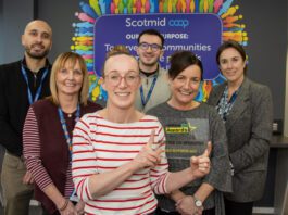 Scotmid celebrates GroceryAid Gold award Members of the Scotmid team stand together in their office holding the GroceryAid Gold trophy.