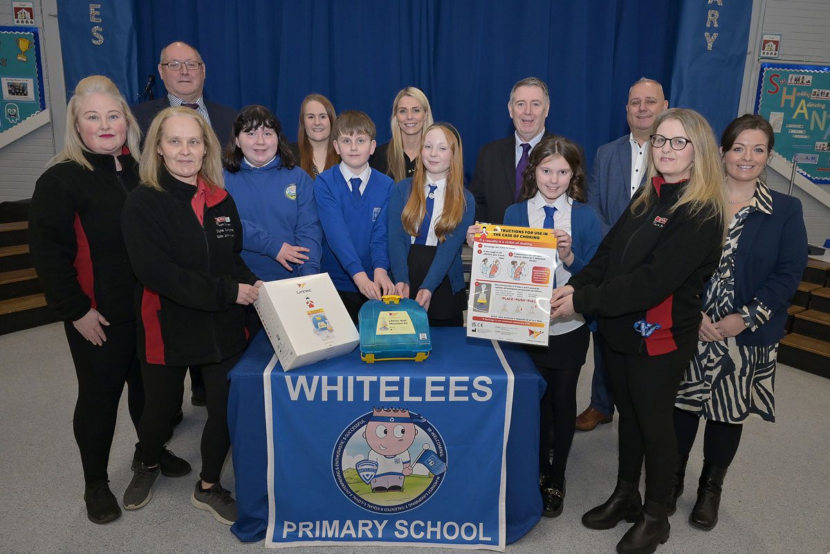 Staff members from Spar Condorrat stands with primary school pupils from Whitelees along with staff members at the school.