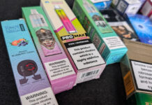 Disposable vape ban ‘a complete failure’ one year on Packs of illicit disposable vapes sit on a counter.