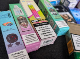 Disposable vape ban ‘a complete failure’ one year on Packs of illicit disposable vapes sit on a counter.