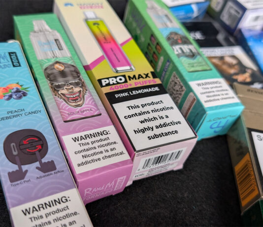 Disposable vape ban ‘a complete failure’ one year on Packs of illicit disposable vapes sit on a counter.