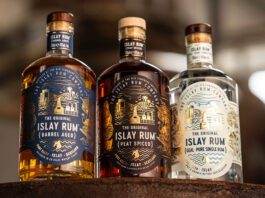 The Islay Rum Distillery takes home global accolade Bottles of The Original Islay Rum Barrel Aged, The Original Islay Rum Geal and The Original Islay Rum Peat Spiced sit on top of a barrel inside the distillery.