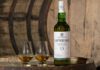 Laphroaig brings back 15 Year Old whisky expression A bottle of Laphroaig 15 Year Old sits on a whisky barrel with two nosing glasses next to the bottle.