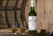 Laphroaig brings back 15 Year Old whisky expression A bottle of Laphroaig 15 Year Old sits on a whisky barrel with two nosing glasses next to the bottle.