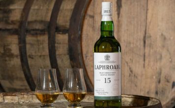 Laphroaig brings back 15 Year Old whisky expression A bottle of Laphroaig 15 Year Old sits on a whisky barrel with two nosing glasses next to the bottle.