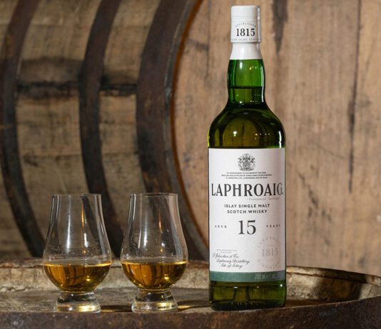 Laphroaig brings back 15 Year Old whisky expression A bottle of Laphroaig 15 Year Old sits on a whisky barrel with two nosing glasses next to the bottle.