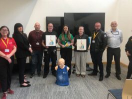 Spar Condorrat spreads its LifeVac mission across Lanarkshire A group of people stand together in a classroom setting with LifeVac devices as well as a practice dummy on the floor.