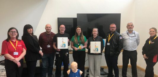 Spar Condorrat spreads its LifeVac mission across Lanarkshire A group of people stand together in a classroom setting with LifeVac devices as well as a practice dummy on the floor.