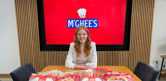 McGhee’s rises to the top in Worldpanel research Aisling McGhee, commercial director at McGhee's, sits at a boardroom table with McGhee's products across the table.