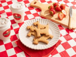 McGhee’s partners with Maggie’s with new Scottie biscuits A plate with McGhee's Scottie dog biscuits on it sits on a gingham blanket with coffee cups with McGhee's logo on them and a chopping board with cut up strawberries on them.