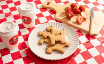 McGhee’s partners with Maggie’s with new Scottie biscuits A plate with McGhee's Scottie dog biscuits on it sits on a gingham blanket with coffee cups with McGhee's logo on them and a chopping board with cut up strawberries on them.