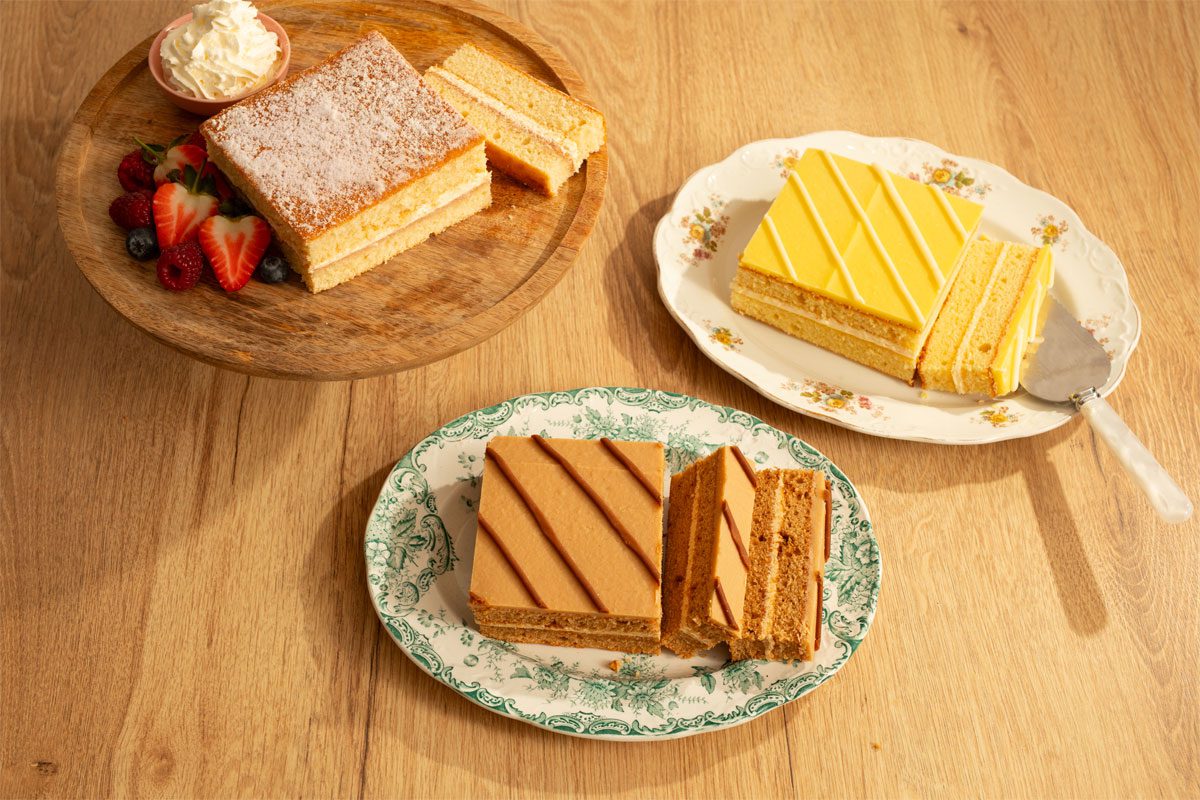The McGhee's range of Tesco-exclusive sponge cakes sit on plates with a slice taken out of them with flavours including Victoria Sponge, Lemon Sponge and Toffee Sponge.