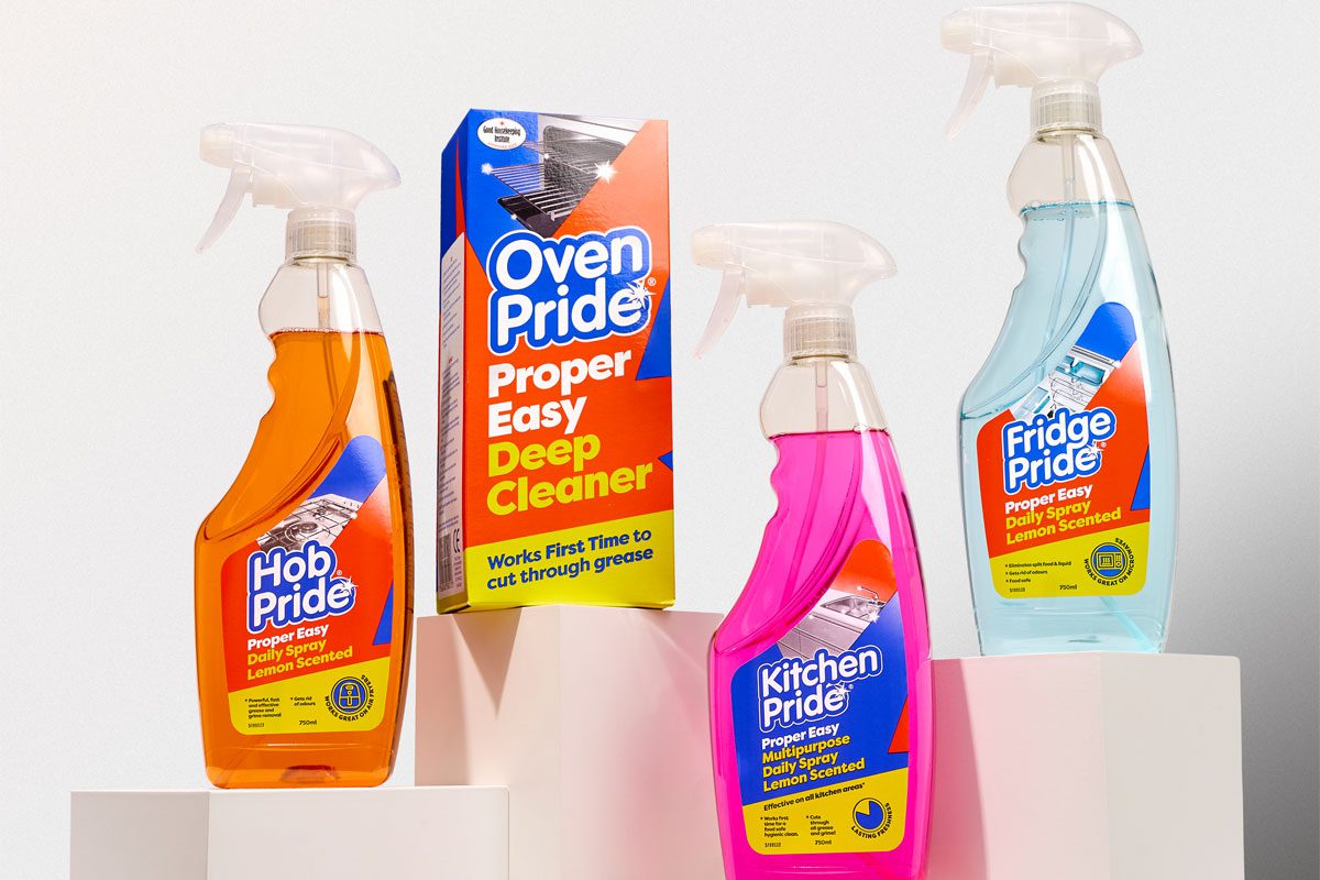 Packs of Oven Pride Hob Pride, Oven Pride, Kitchen Pride and Fridge Pride are standing on white stands against a white background.