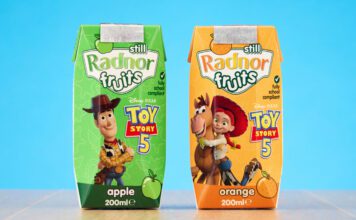 Radnor Hills unveils new Toy Story 5 collaboration Packs of Radnor Hills Toy Story 5 collaboration in Apple and Orange flavours, these are set against a blue background on top of a wooden table.