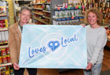 SGF encourages stores to fly the flag for local businesses Graham Watson, president at the SGF, stands holding a flag with the Scotland Loves Local logo on it with colleague Katie McKenzie-Wilson.