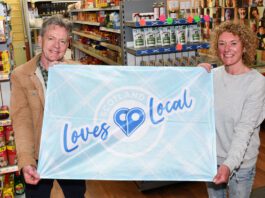 SGF encourages stores to fly the flag for local businesses Graham Watson, president at the SGF, stands holding a flag with the Scotland Loves Local logo on it with colleague Katie McKenzie-Wilson.