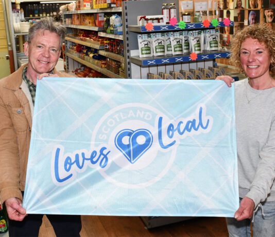 SGF encourages stores to fly the flag for local businesses Graham Watson, president at the SGF, stands holding a flag with the Scotland Loves Local logo on it with colleague Katie McKenzie-Wilson.