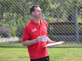 Andy Murray steps into coach role in Walker’s Shortbread campaign Andy Murray stands in a tennis court holding a mug that says 'Walkers Spectator Coach' on it.