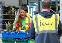 bp deepens relationship with Felix Two people in high-vis jackets stand talking whilst moving crates of surplus food. The jacket facing the camera features the Felix logo.