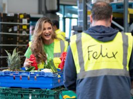 bp deepens relationship with Felix Two people in high-vis jackets stand talking whilst moving crates of surplus food. The jacket facing the camera features the Felix logo.