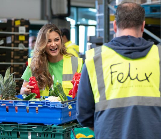 bp deepens relationship with Felix Two people in high-vis jackets stand talking whilst moving crates of surplus food. The jacket facing the camera features the Felix logo.